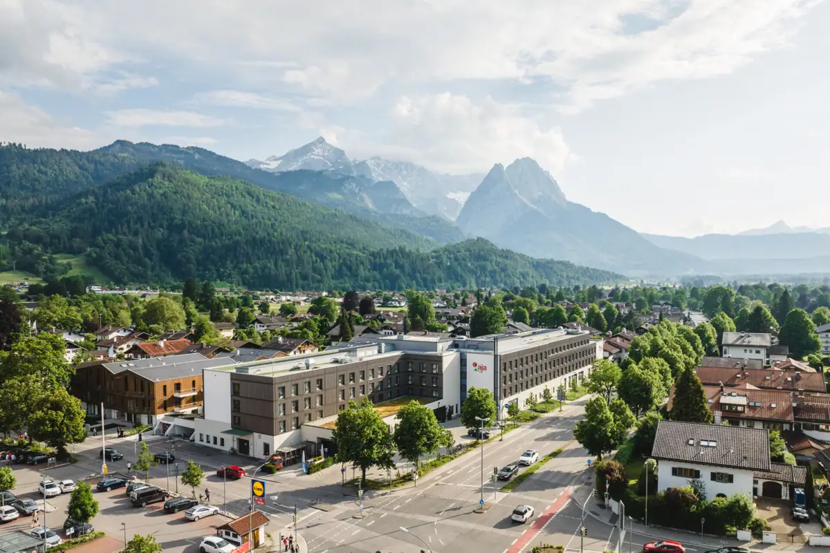 aja Garmisch-Partenkirchen Stadsgezicht met veel gebouwen en bomen onder een bewolkte hemel.