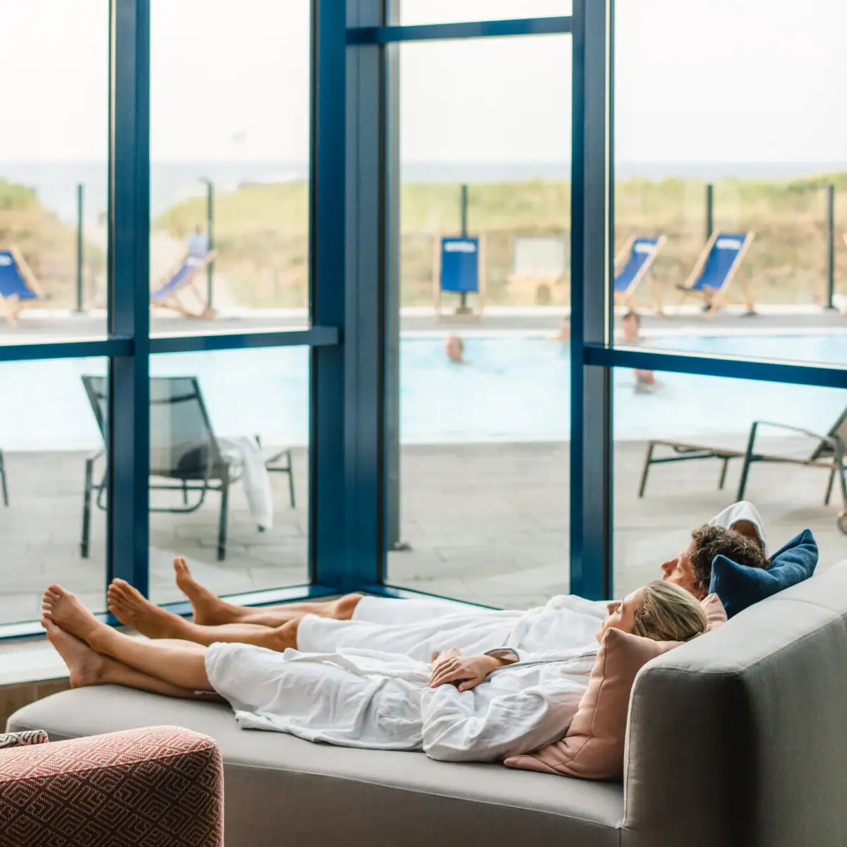 Wellnessruimte aja Warnemünde Een koppel ligt op een sofa in de wellnessruimte.