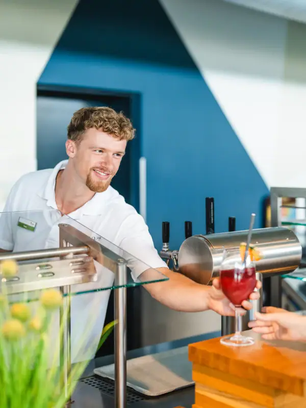 Een man geeft een klant een drankje.