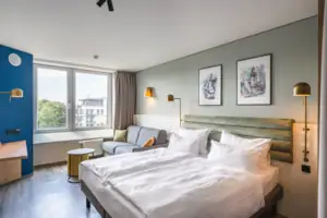 Kamers in het aja Warnemünde Een kamer met een tweepersoonsbed, foto's aan de muur en een bank.