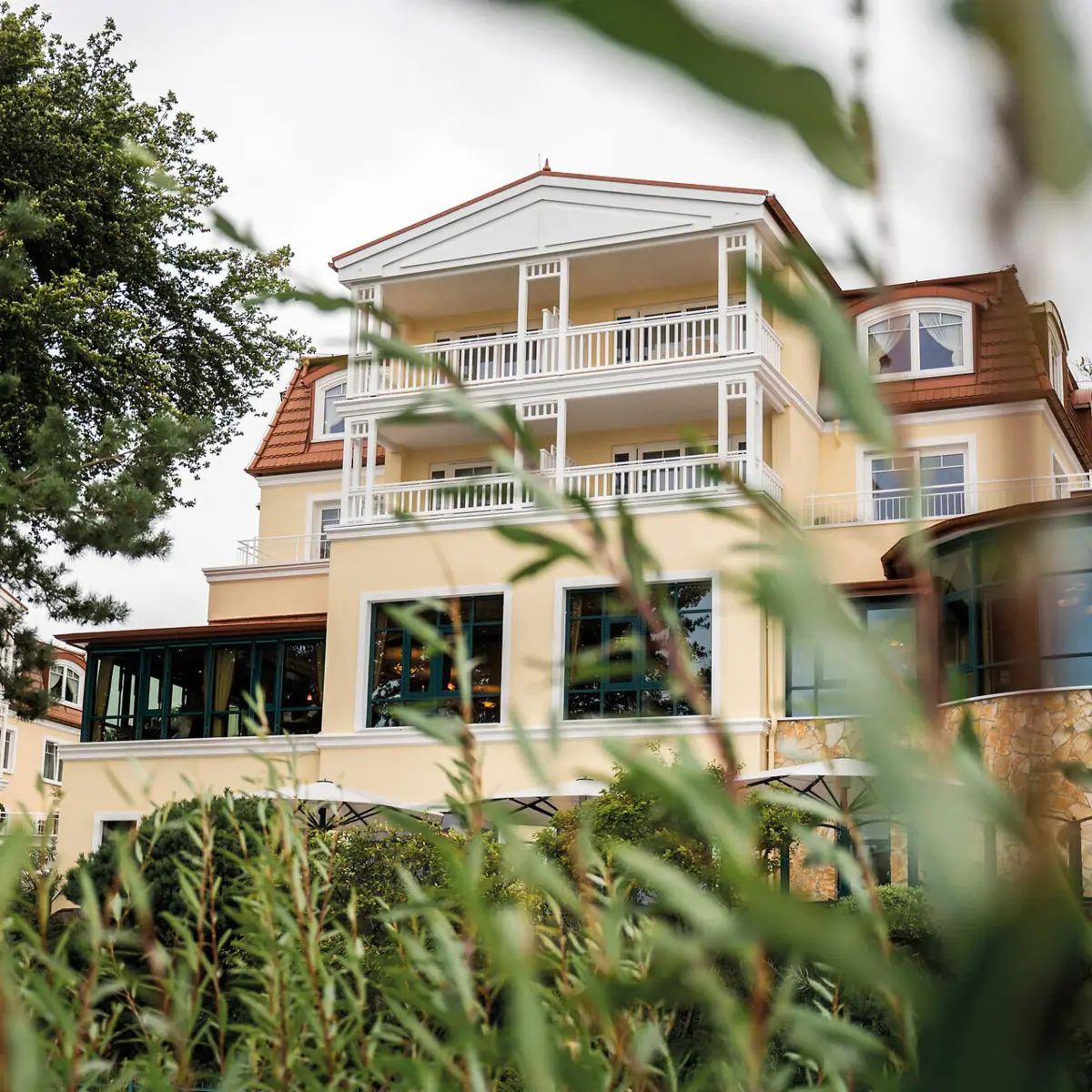 aja Hotel Usedom Een gebouw met ramen en bomen op de achtergrond.
