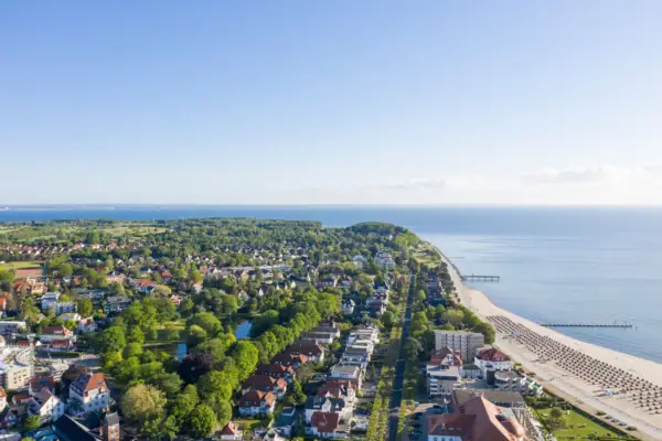 Luchtfoto van een stad aan het water met gebouwen en bomen op de voorgrond.