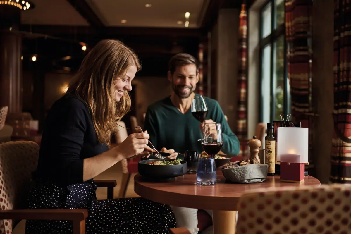 Een man en een vrouw eten aan een tafel.