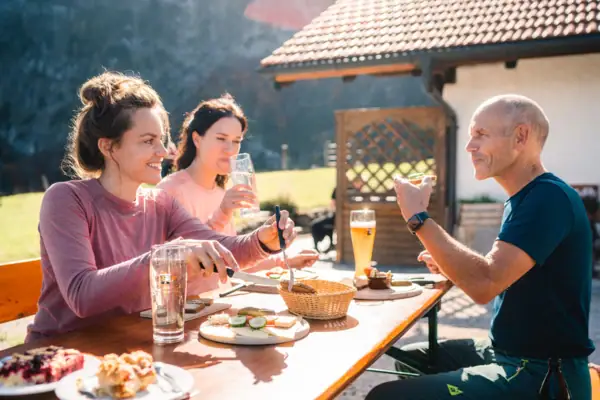 Alpenweide Een groep mensen zit aan tafel en eet.