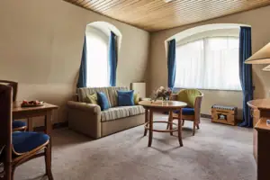 Junior Suite Woonkamer met bank en tafel.