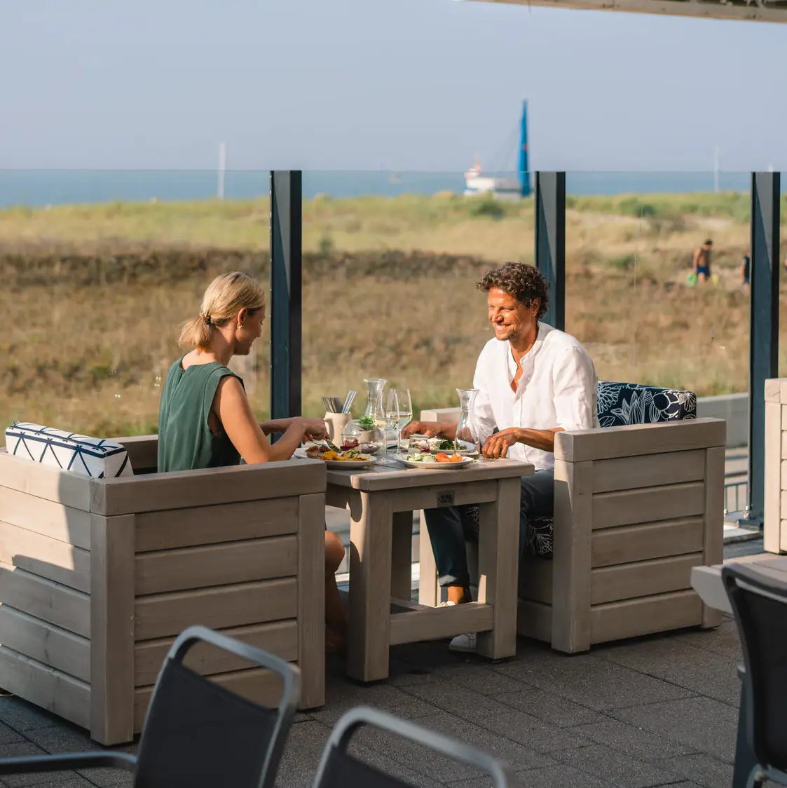 Terras aja Warnemünde Een groep mensen zit buiten aan een tafel.