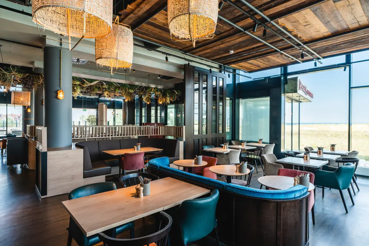 Restaurant bij aja Warnemünde Een restaurant met tafels en stoelen, ingericht en gedecoreerd in maritieme stijl.