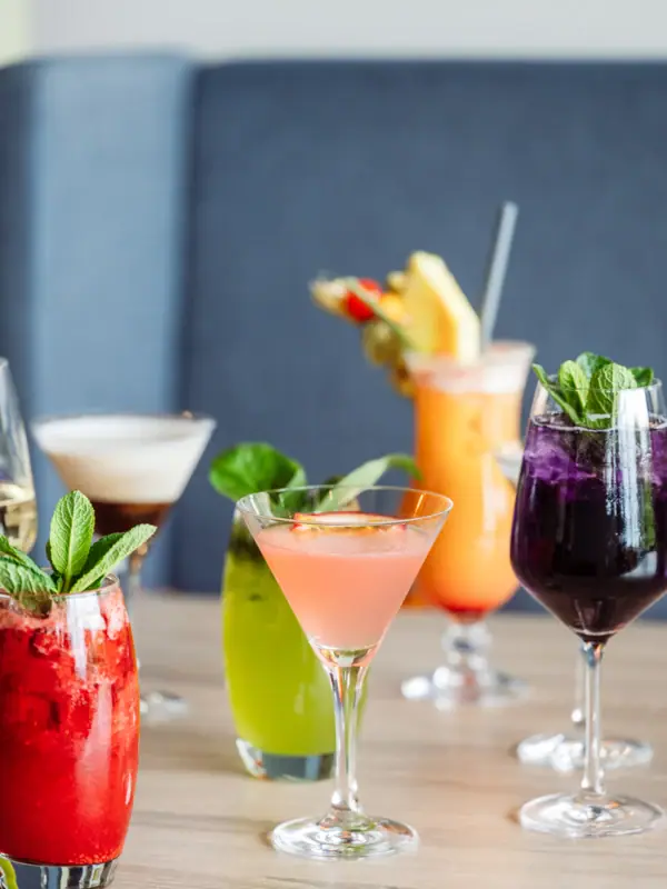 Eine Auswahl an Cocktails mit Garnitur auf einem Tisch.