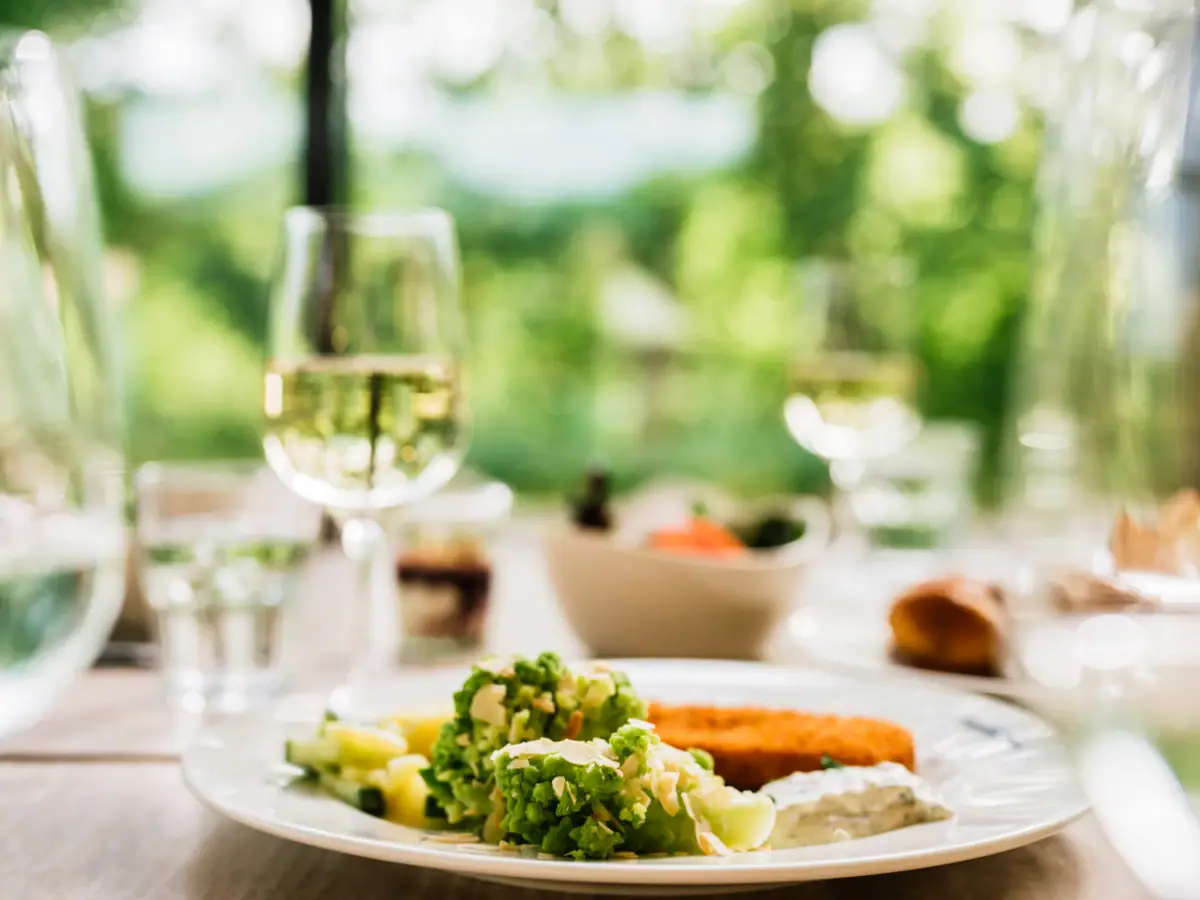 Restaurant aja Bad Saarow Een bord eten en een glas wijn.