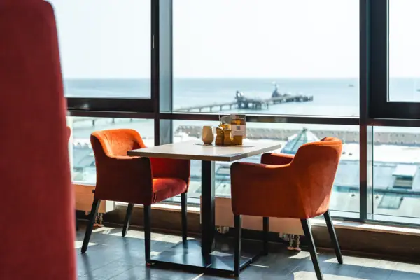 Ein Tisch mit Stühlen und Blick auf das Meer.