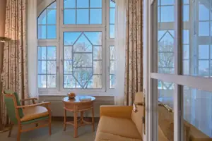 Suite Woonkamer met bank en tafel, raam op de achtergrond.