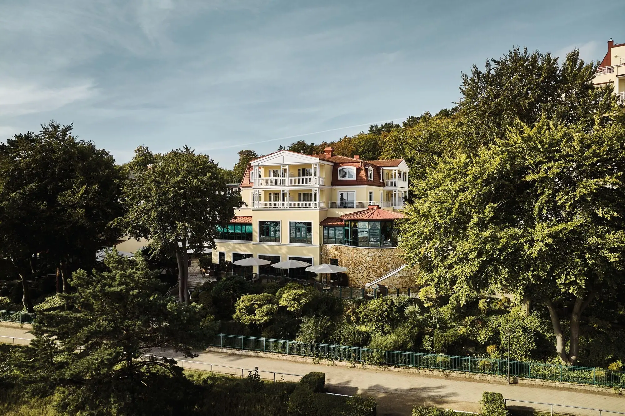 aja Bansin Buitenaanzicht van de aja Bansin omringd door groene bomen op een zonnige dag.