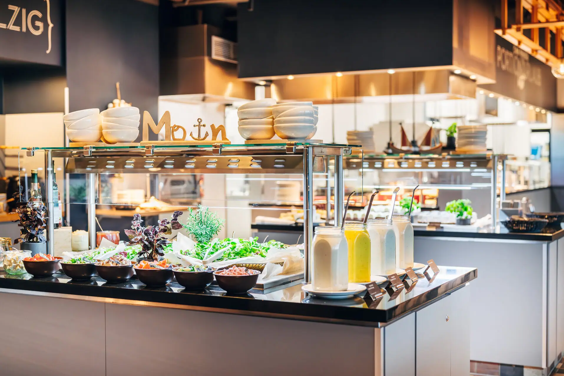 Toonbank met salades en potten gevuld met verschillende dressings.