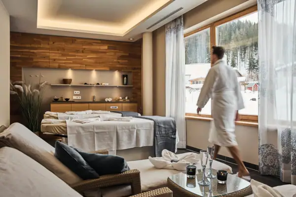 Een man loopt door de SPA-suite met een bed en een tafel.
