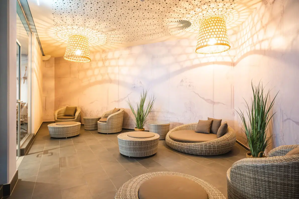 Een kamer met rieten meubels en kamerplanten.