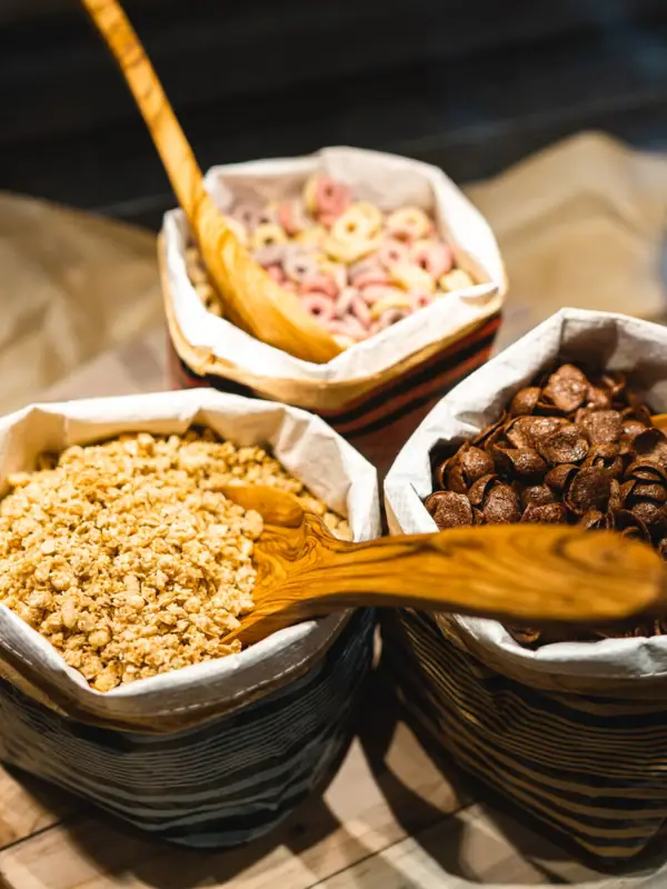 Een stapeltje kommen met muesli en een lepel.