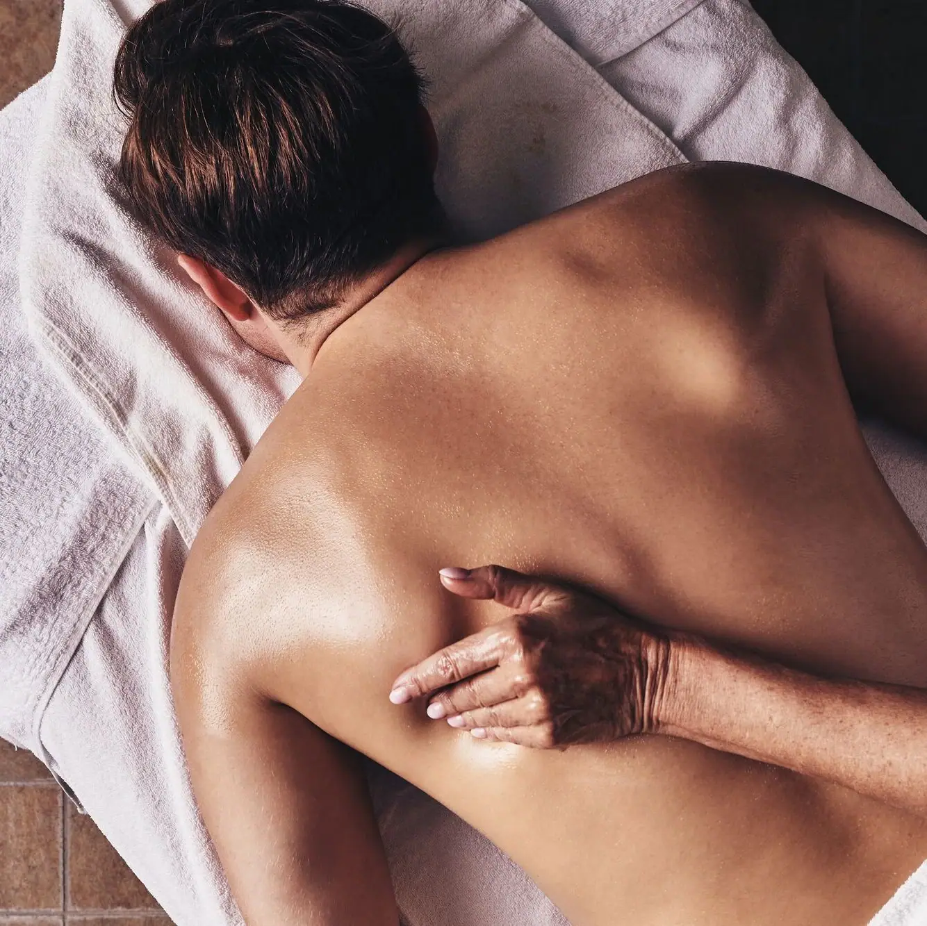 Iemand ligt op zijn rug op een handdoek.