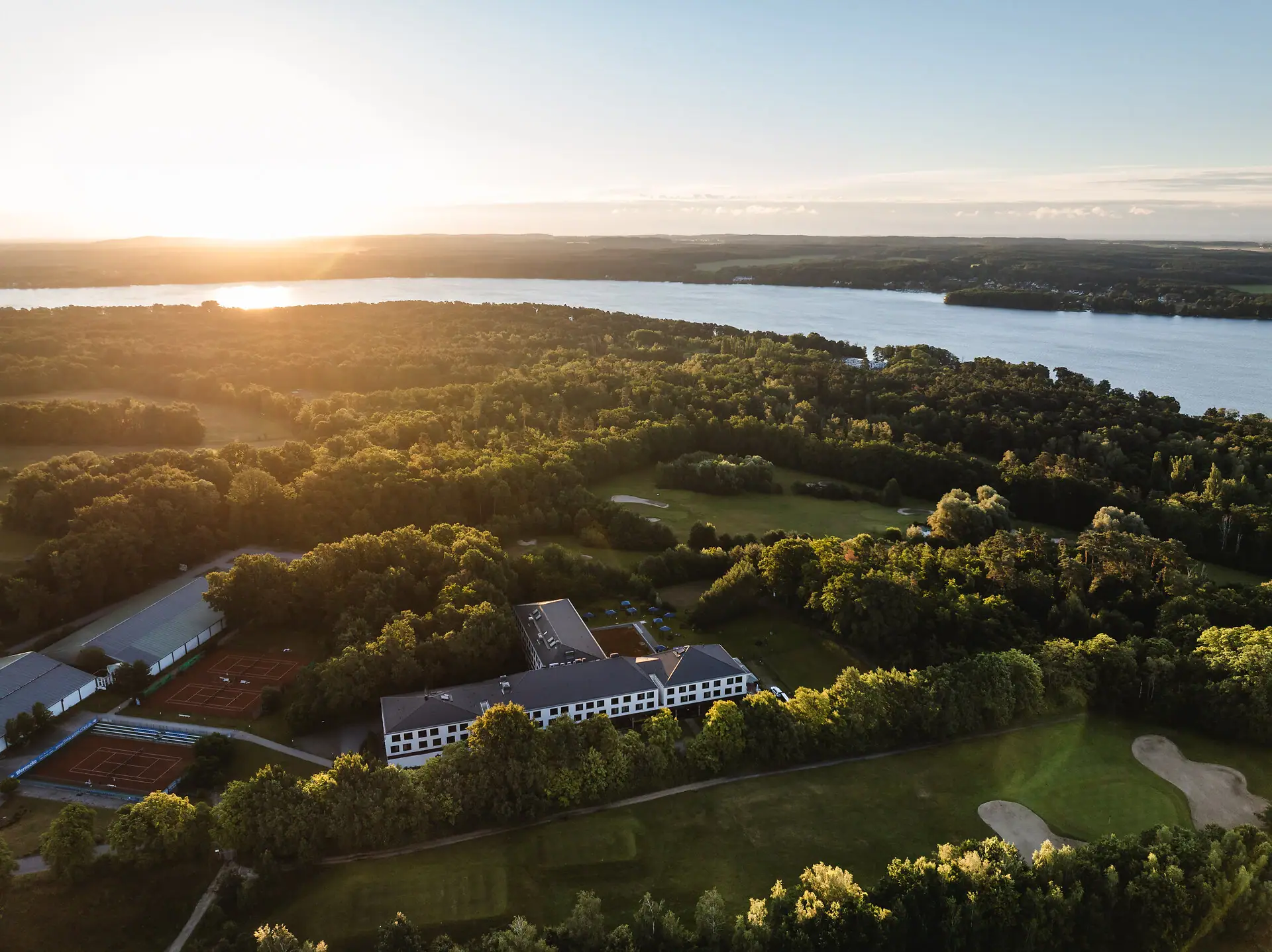 aja Bad Saarow Groot wateroppervlak met een gebouw en bomen op de voorgrond.