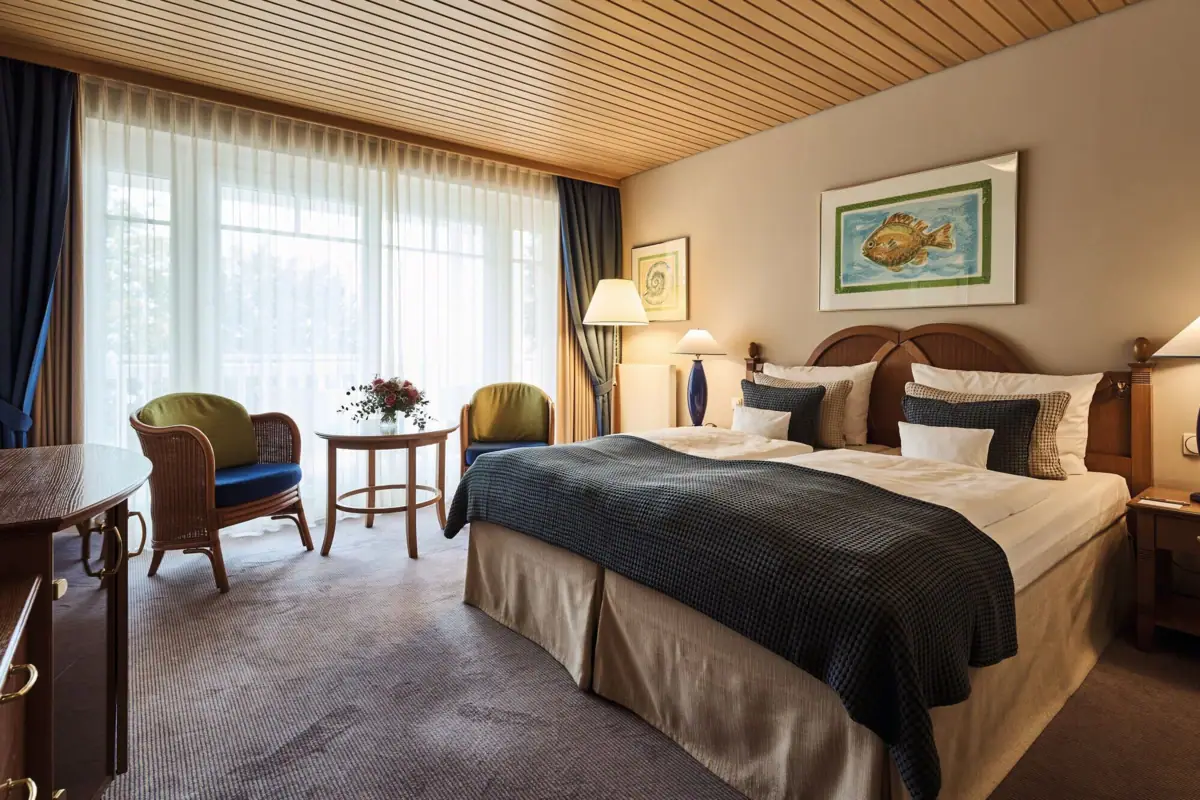 Een slaapkamer met een bed en stoelen.