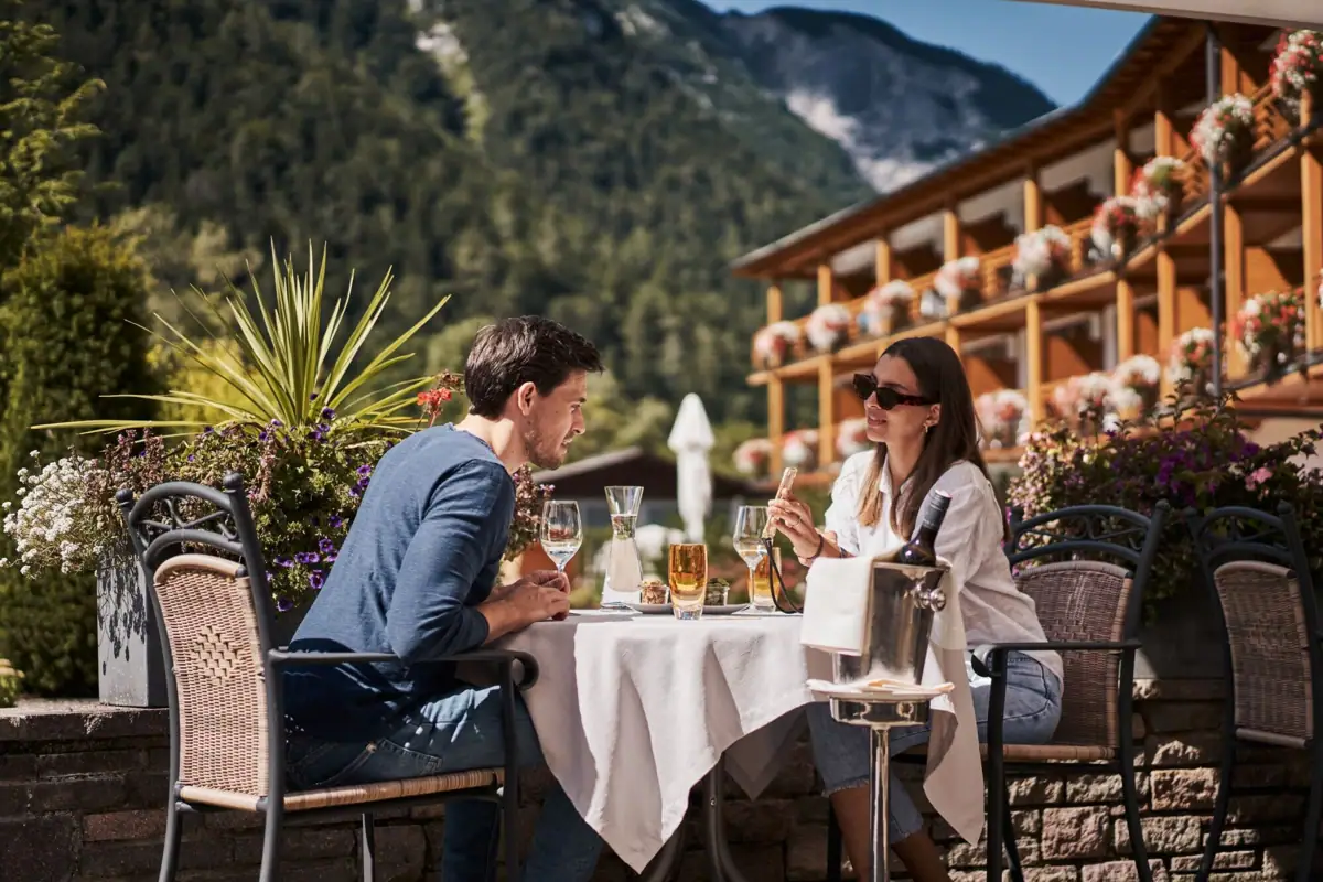 Een man en een vrouw zitten aan een tafel met drankjes.