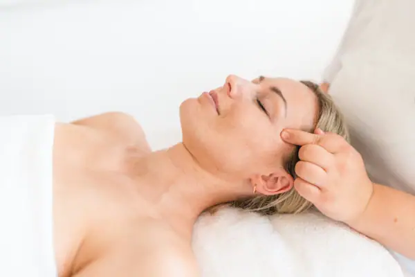 Vrouw ligt op een massagetafel.