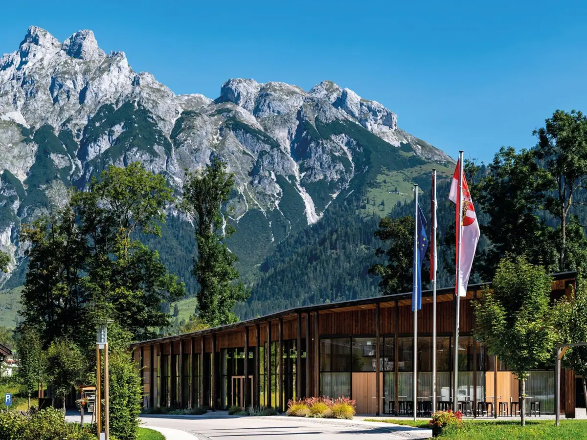 Conferentiecentrum Conferentiecentrum met vlaggen tegen een bergachtige achtergrond.