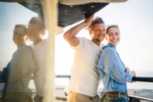 Ein Mann und eine Frau stehen lächelnd auf einem Boot.