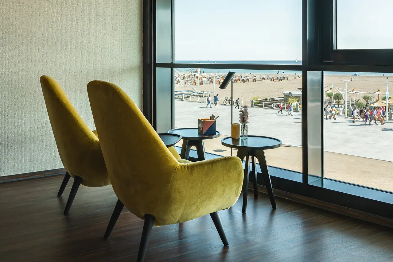 Een kamer met gele stoelen en een tafel.