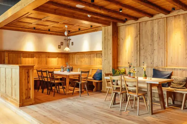 Beierse salon Een kamer met houten muren, tafels en stoelen.