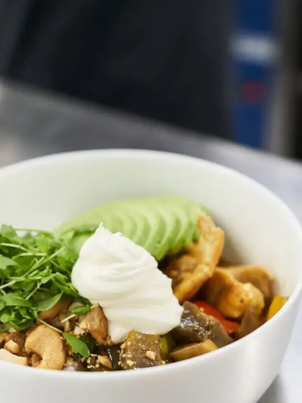 Een schaal met eten op een tafel.