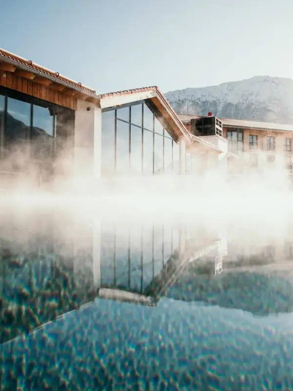 Een gebouw met water en een berg op de achtergrond.