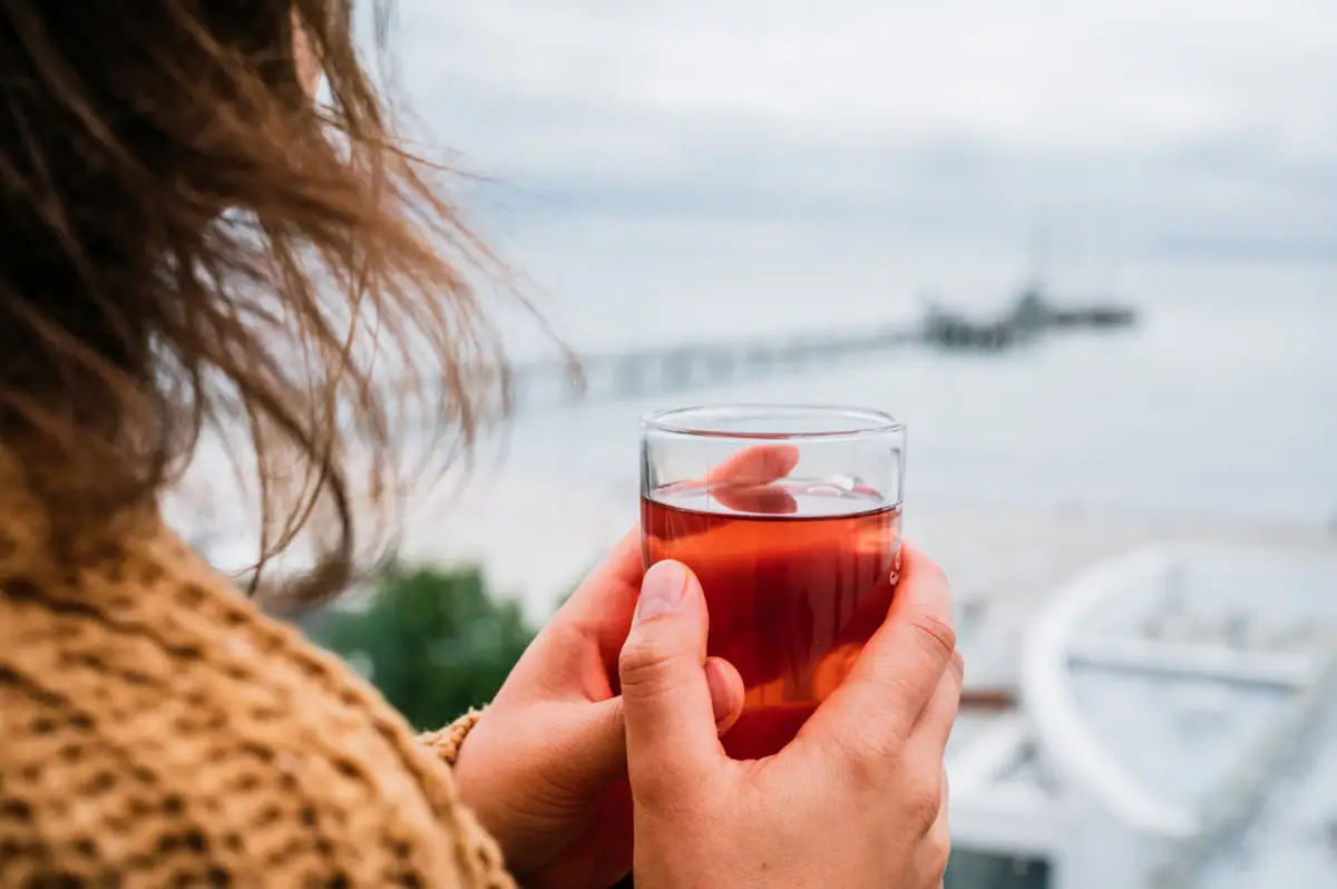 Uitzicht op de thee Iemand houdt een glas thee vast.