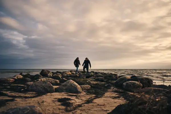 Göhren strand Twee mensen staan op een rotsstrand.