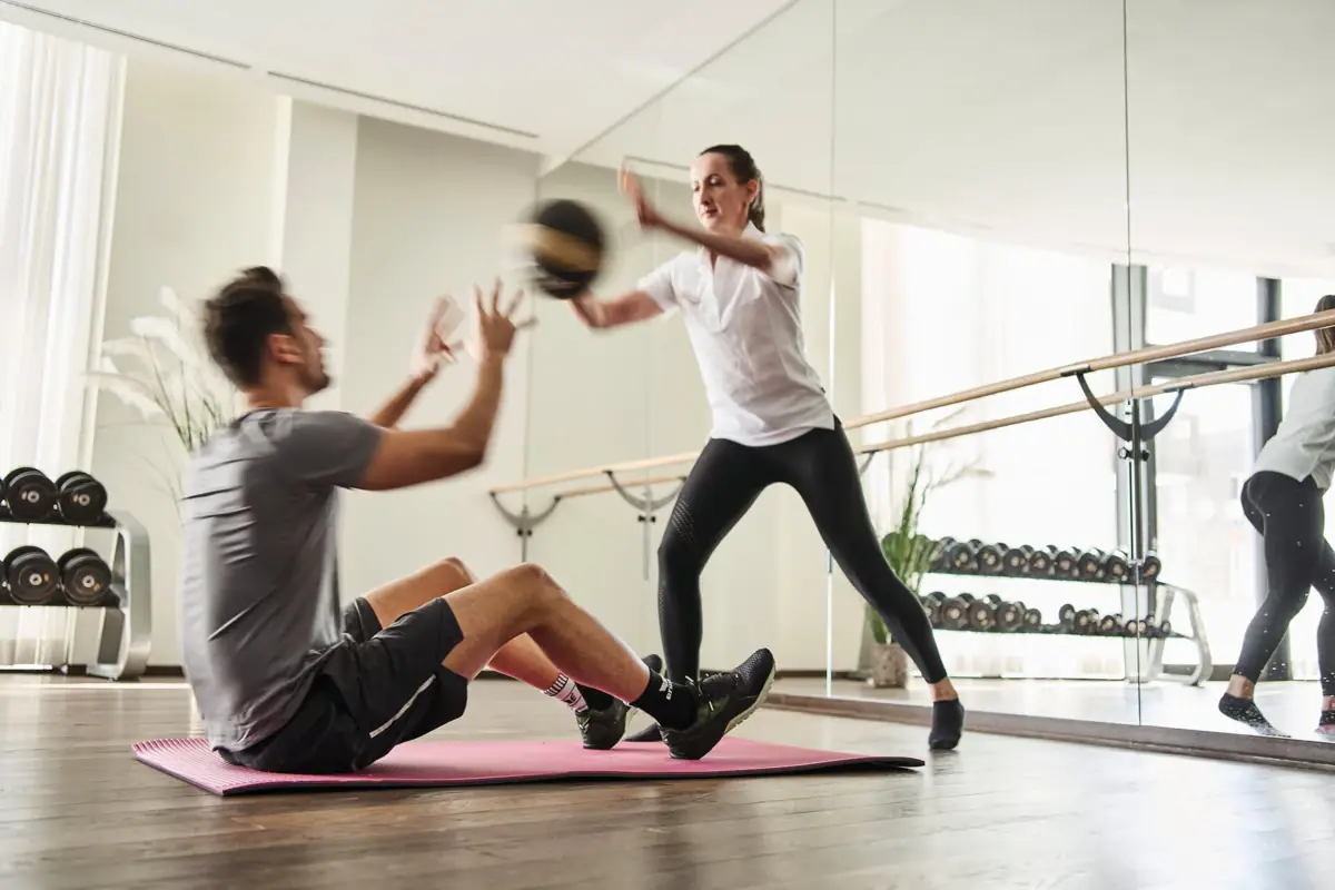Een man en een vrouw trainen in een sportschool.