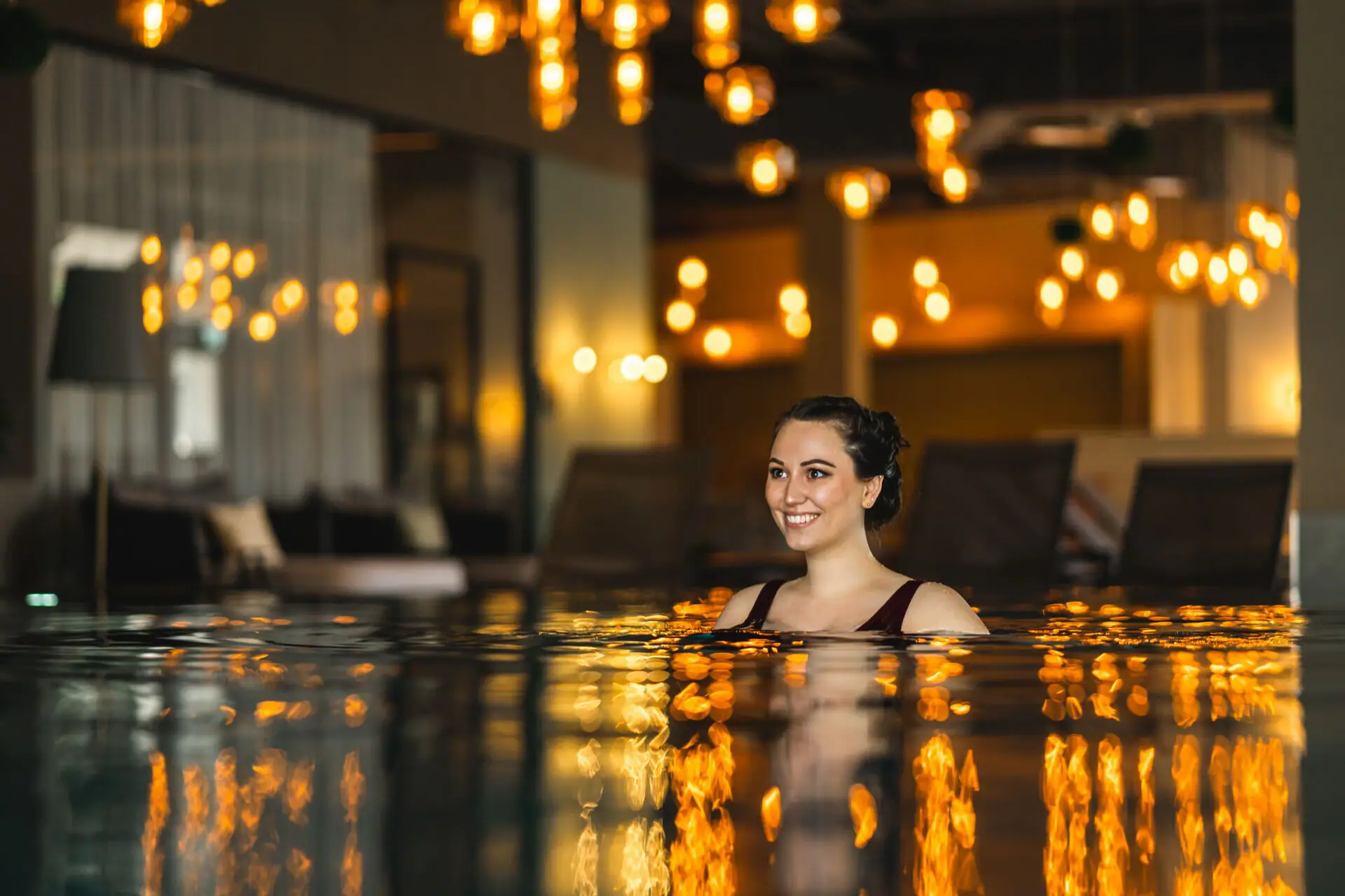 Overdekt zwembad Een vrouw lacht in een zwembad.