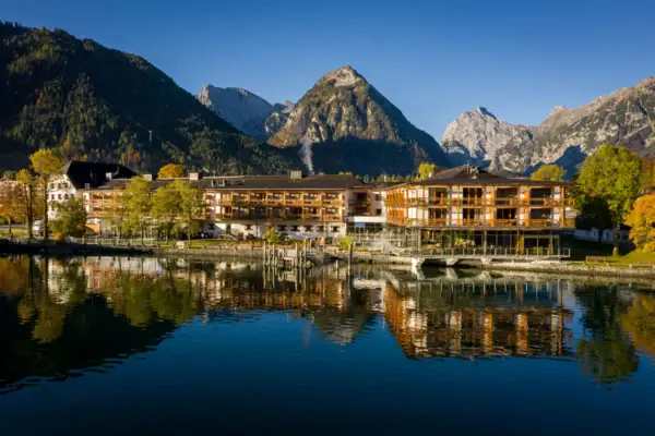 aja Fürstenhaus aan de Achensee Een gebouw naast een waterpartij met bomen op de achtergrond.