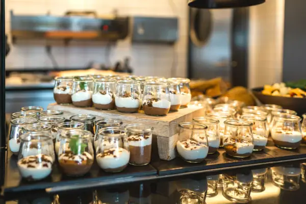 Een groep kleine glazen gevuld met desserts.