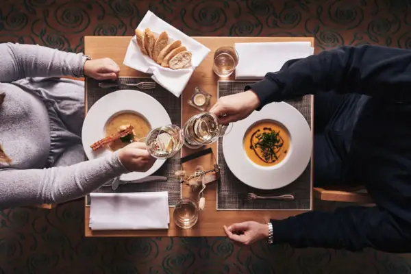 Abendessen Restaurant Eine Gruppe von Menschen sitzt an einem Tisch mit Tellern und Weingläsern.