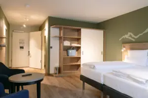 Een kamer met een bed en stoelen.