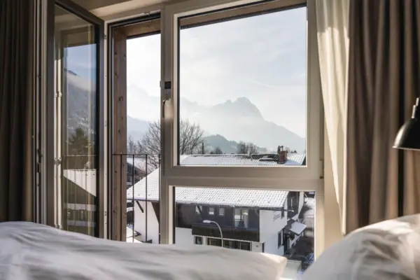 Een hotelkamer in het aja Garmisch-Partenkirchen met een raam en uitzicht op de bergen.