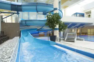 Waterglijbaan in een gebouw boven een zwembad.