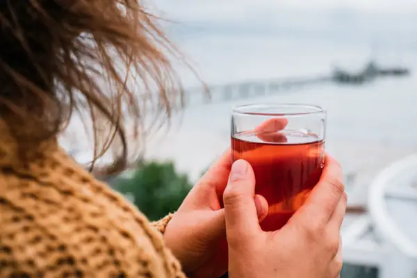 Eén persoon houdt een glas met drinken vast.