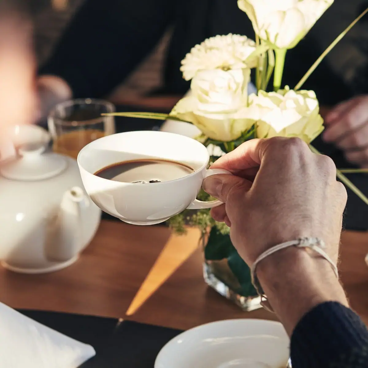 Een persoon houdt een kop koffie vast.