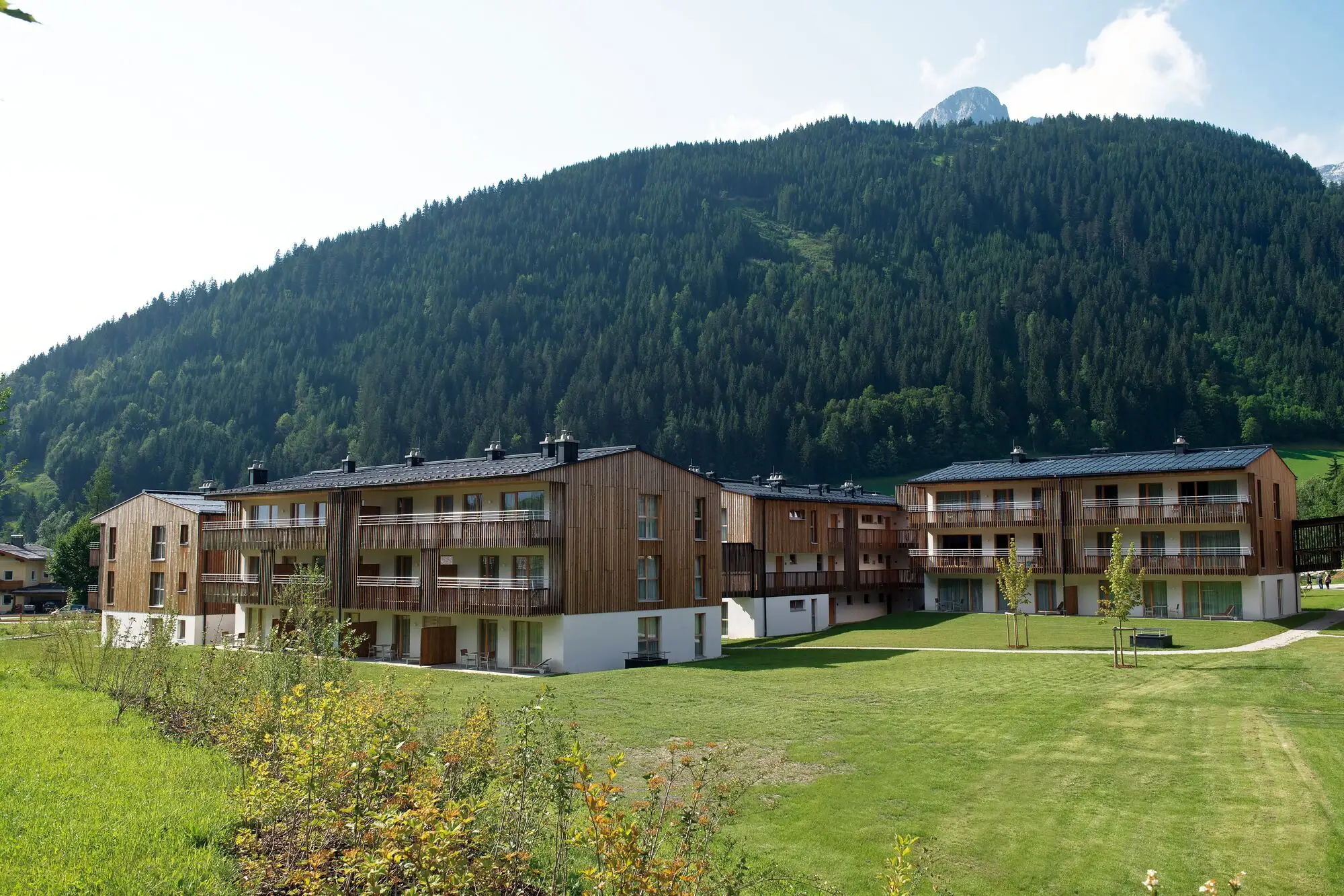 Vakantiewoningen Werfenweng Een groep gebouwen met bomen op de achtergrond.