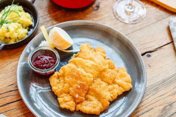 Schnitzel in de aja Bar Ruhpolding Een bord eten op een tafel.
