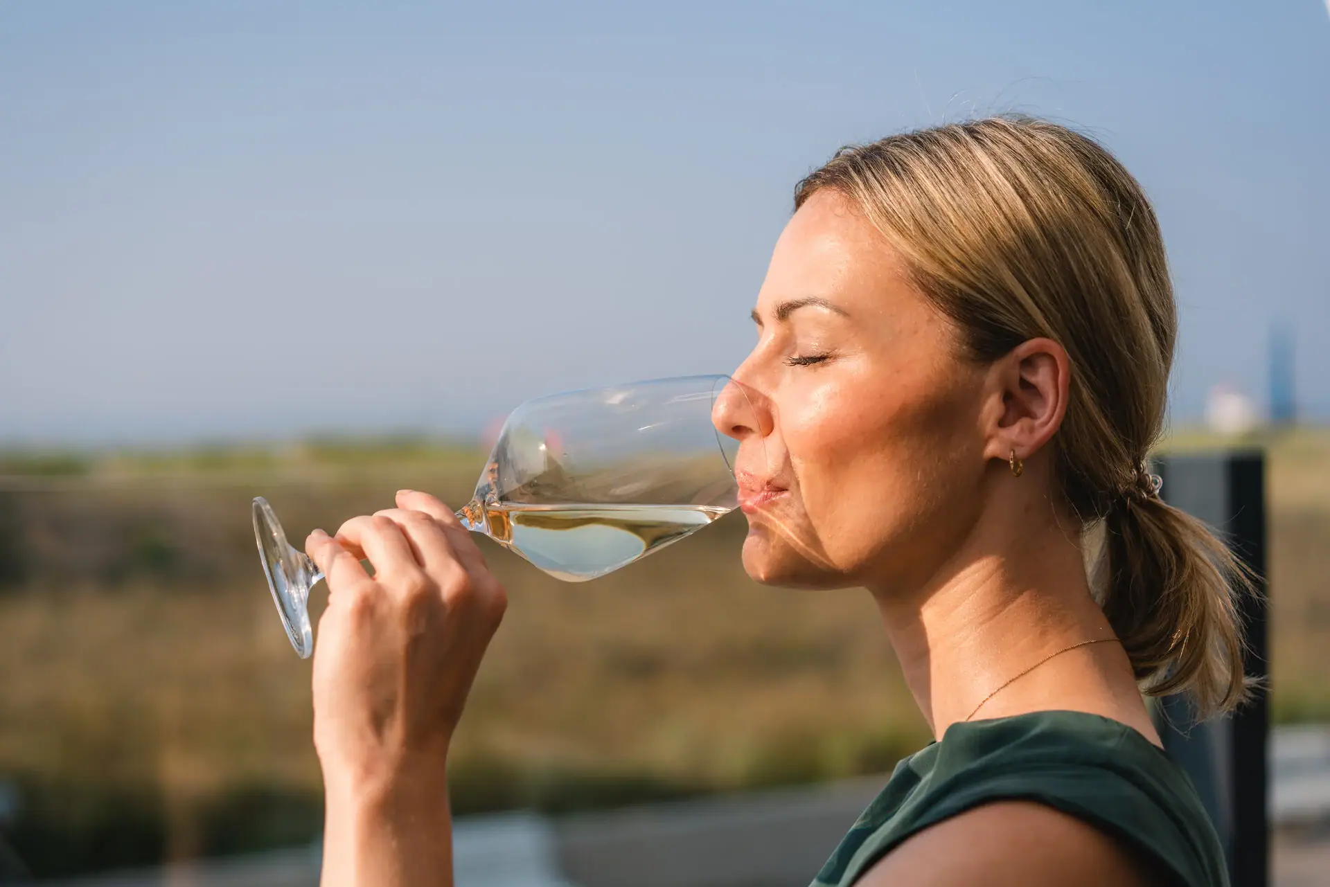 Drankjes bij aja Warnemünde Een vrouw drinkt uit een wijnglas.