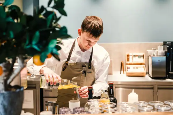 Barman bij de zwembadbar Een man giet vloeistof in een glas.