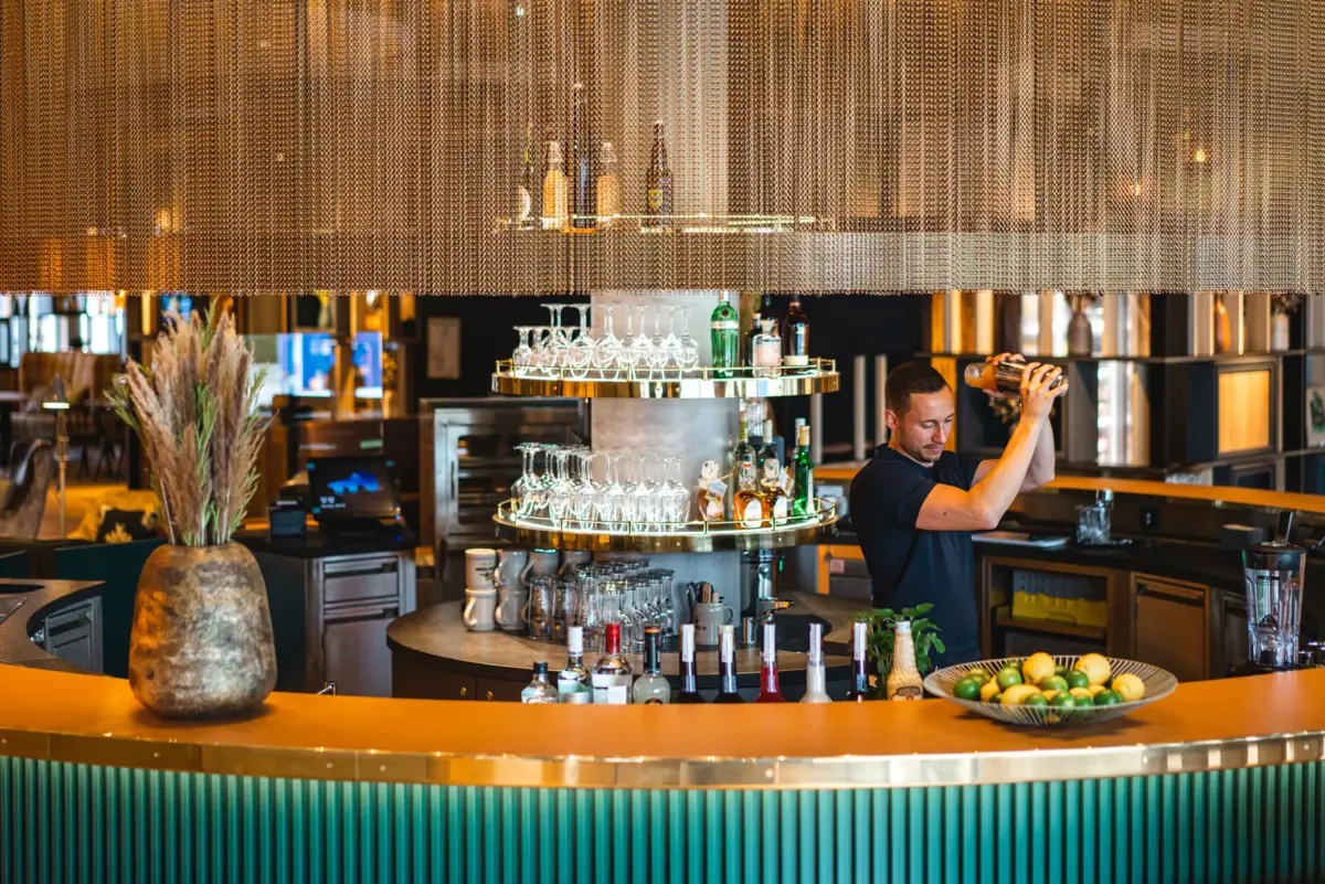 Een man schenkt een drankje in in een bar.