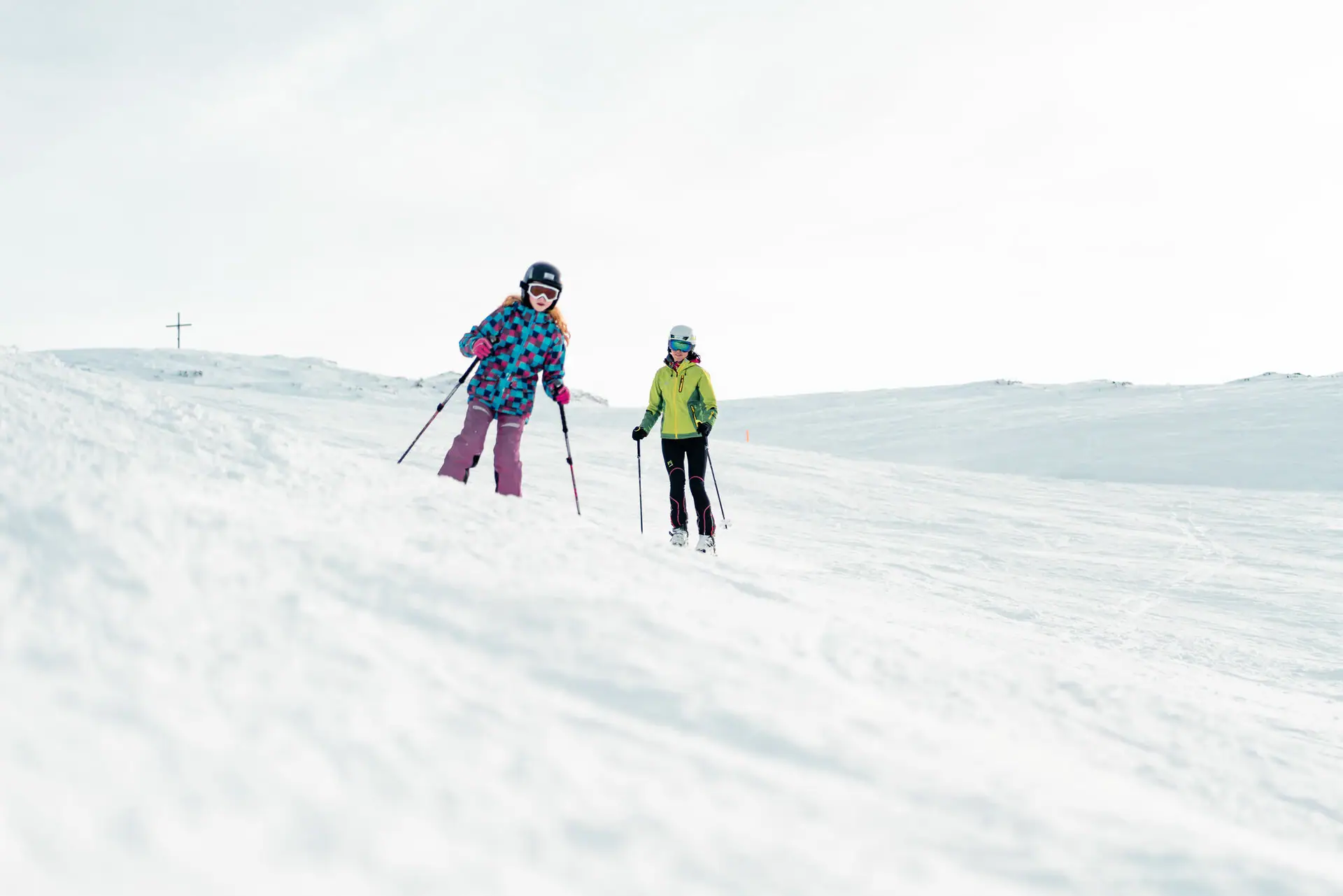 Skipiste Twee mensen skiën op een besneeuwde heuvel.