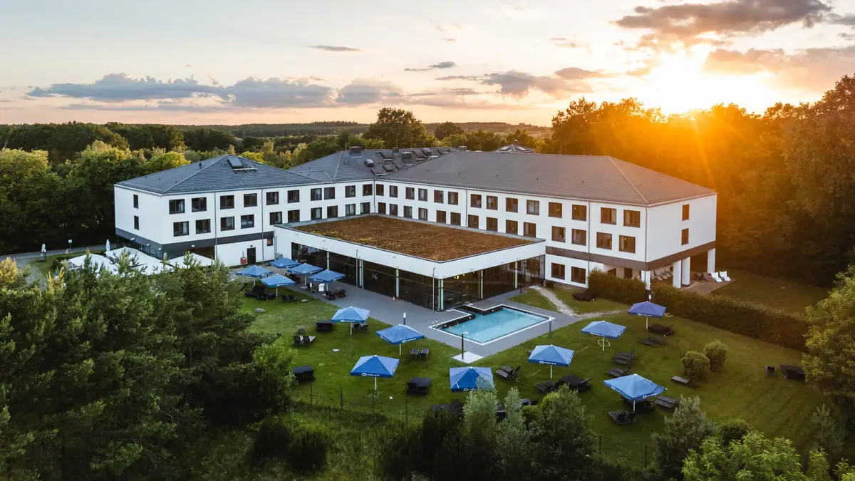 aja Bad Saarow Een gebouw met een zwembad en parasols in het centrum.